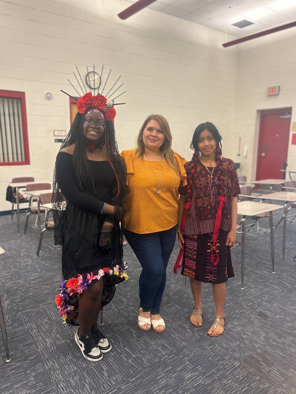 A Campbell Middle School student was awarded Best of Show for Traditional Dress. She is La Catrina on the left, Ja"Nyla Henry. Yalili Diaz-Sales was awarded 2nd place for her presentation on her Guatemalan Traditional Dress. Ms. Karelys Nunuz is their teacher, center.